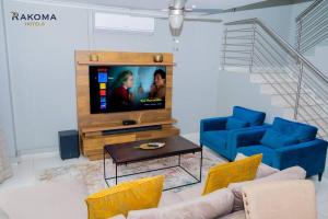 a living room with a tv and two blue chairs at Deluxe 3 Bed Apartment in Polokwane