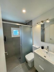 a bathroom with a shower and a toilet and a sink at Casa la Marinera in Binibeca