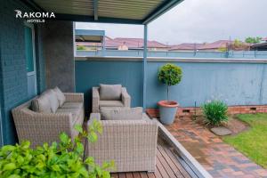a patio with wicker furniture on a house at Deluxe 3 Bed Apartment in Polokwane