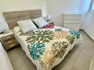 a bedroom with a bed with a colorful comforter at Casa la Marinera in Binibeca