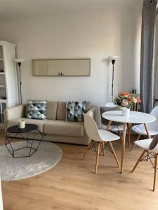 un salon avec un canapé, une table et des chaises dans l'établissement Cosy appartement la Promenade des Anglais, à Nice