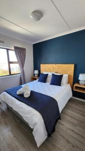 1 dormitorio con 1 cama grande y paredes azules en Villa Nordica - 2 bedroom self-catering apartment, en Ciudad del Cabo