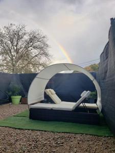 Posto letto in tenda con arcobaleno sullo sfondo. di Bulles étoilées Appartement avec jacuzzi privé a Montrevel-en-Bresse