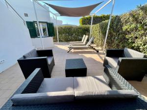 a patio with two couches and a table and chairs at Casa la Marinera in Binibeca