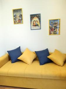 a couch with blue and yellow pillows on it at Hotel NBL Terrace Rooms in Tbilisi City