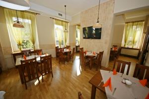 a restaurant with tables and chairs with orange arrows at Hotel Zamkowy in Słupsk