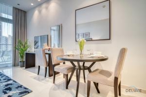 una sala da pranzo con tavolo e sedie di Lively Studio at DAMAC Celestia A Dubai South by Deluxe Holiday Homes a Dubai