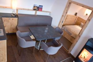 mały pokój ze stołem, krzesłami i łóżkiem w obiekcie Gurgltal Refugia w mieście Tarrenz