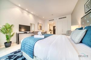 a bedroom with a large bed and a tv at Lively Studio at DAMAC Celestia A Dubai South by Deluxe Holiday Homes in Dubai