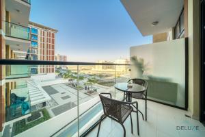 a balcony with a table and chairs and a view of a city at Lively Studio at DAMAC Celestia A Dubai South by Deluxe Holiday Homes in Dubai