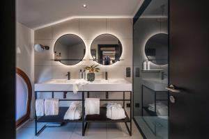 a bathroom with a sink and two mirrors at LUGANODANTE - We like you in Lugano