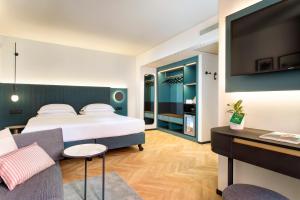 a hotel room with a bed and a couch at LUGANODANTE Boutique & Lifestyle Hotel in Lugano