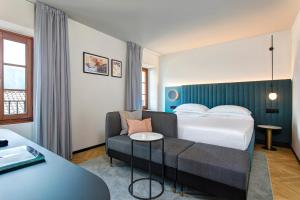 a hotel room with a bed and a couch at LUGANODANTE Boutique & Lifestyle Hotel in Lugano +101 photos