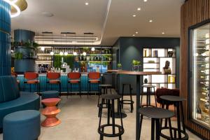 a bar with red and blue stools in a restaurant at LUGANODANTE - We like you in Lugano