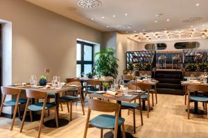 a restaurant with wooden tables and blue chairs at LUGANODANTE Boutique & Lifestyle Hotel in Lugano
