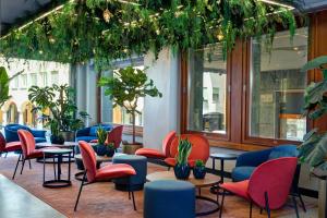 a waiting room with colorful chairs and plants at LUGANODANTE - We like you in Lugano
