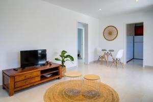 a living room with a tv and two stools at Cas Buc - Villa con piscina a pasitos del mar in Cala Blanca