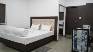 1 dormitorio con 1 cama con sábanas y almohadas blancas en POD N BEYOND SMART HOTEL @BISTUPUR en Jamshedpur