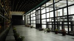 POD N BEYOND SMART HOTEL @BISTUPUR في جمشيدبور: مدخل مع نباتات الفخار في مبنى به نوافذ