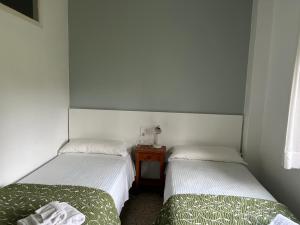 two twin beds in a room with a table at Pazo Pias P in Ramallosa
