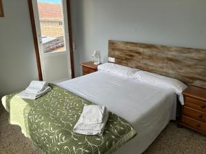 1 dormitorio con 1 cama con cabecero de madera y ventana en Pazo Pias P, en Ramallosa