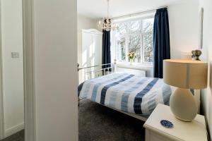 een slaapkamer met een bed en een raam bij Tegfryn (Sleeps 8), 5*, Sea View, Borth y Gest in Porthmadog