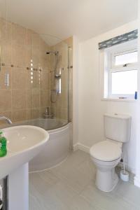 a bathroom with a tub and a toilet and a sink at Tegfryn (Sleeps 8), 5*, Sea View, Borth y Gest in Porthmadog