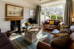 a living room with a couch and a tv at Tegfryn (Sleeps 8), 5*, Sea View, Borth y Gest in Porthmadog
