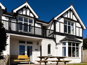 a house with a picnic table in front of it at Tegfryn (Sleeps 8), 5*, Sea View, Borth y Gest in Porthmadog