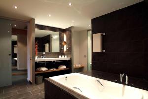 a bathroom with a tub and a large mirror at Hotel Món Sant Benet in Sant Fruitos de Bages +50 photos