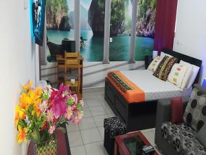 a bedroom with a bed and flowers in a room at Magnifique Studio Meuble in Abidjan