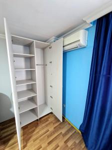 a bedroom with a white closet and a blue curtain at Guesthouse Gorgasali 57 in Batumi