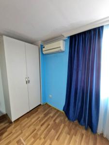 an empty room with a blue wall and a window at Guesthouse Gorgasali 57 in Batumi