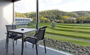 a dining room with a table and chairs and a large window at Hotel Món Sant Benet in Sant Fruitos de Bages