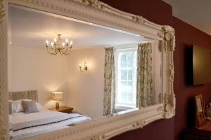 een spiegel in een slaapkamer met een bed en een raam bij The Nags Head in Montgomery