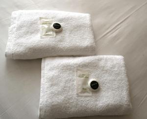 3 asciugamani posti sopra un letto di Charlie Hotel a Londra