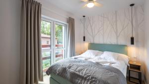 a bedroom with a bed and a large window at Sun & Snow Holiday Mountain Residence in Świeradów-Zdrój