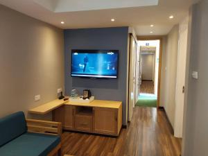 ein Wohnzimmer mit einem Flachbild-TV an der Wand in der Unterkunft Le Grand Bleu Hotel in Trou aux Biches