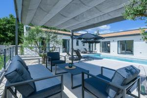 eine Terrasse mit Stühlen, einem Sonnenschirm und einem Pool in der Unterkunft Villa Vetosa by IstriaLux in Žminj