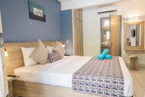 a bedroom with a large white bed with blue walls at Le Grand Bleu Hotel in Trou aux Biches