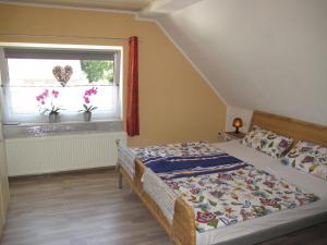 1 dormitorio con cama y ventana en Ferienhaus STICKLIESEL DITZ125, en Ditzum