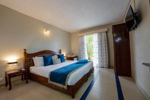 a bedroom with a large bed and a window at Le Grand Bleu Hotel in Trou aux Biches