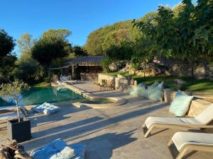un patio trasero con piscina y terraza de madera en Guest House Encantada en Nimes