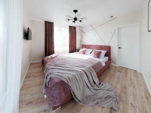 1 dormitorio con 1 cama grande y suelo de madera en VIP Апартаменти Червоної Калини Сихів Новобудова en Leópolis