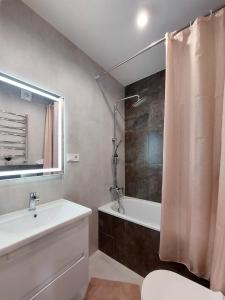 a bathroom with a sink and a tub and a shower at VIP Апартаменти Червоної Калини,56а Сихів Новобудова in Lviv