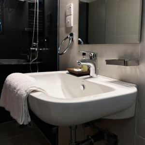 lavabo blanco en el baño con espejo en Cliveland Residence, en Kandy