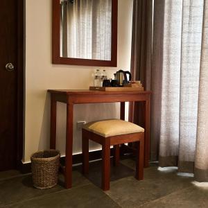 escritorio de madera con taburete y espejo en Cliveland Residence, en Kandy