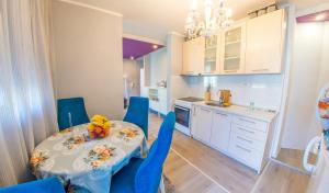 uma pequena cozinha com uma mesa e cadeiras azuis em Apartment Focus em Mostar