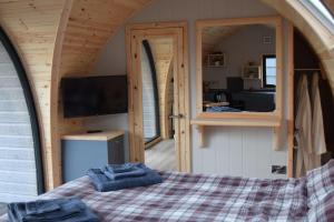 a bedroom in a tiny house with a bed at Oakwood Luxury Glamping 