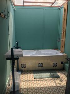 a bathroom with a tub and a tiled floor at Bohemyan Blue Stay in Alibaug